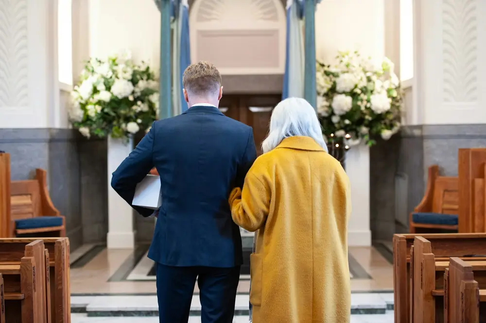 Two people walking up the aisle together at a memorial service