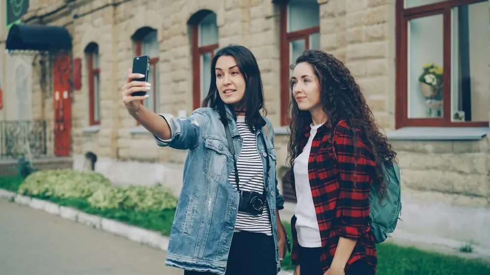 Two friends taking a selfie while exploring a city